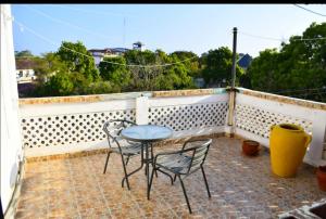 a patio with a table and chairs on a balcony at Mavericks Convenient Cozy Loft in Diani's CBD in Ukunda