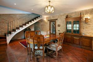 a dining room with a wooden table and a staircase at Casa Maro Prenafeta in Prenafeta