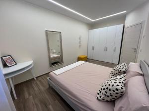 una camera con letto, scrivania e specchio di Appartamento Monte a Ponte Caffaro