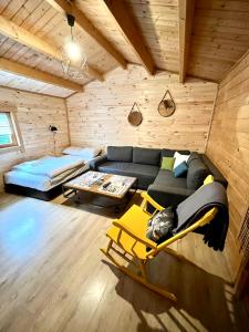 a living room with a couch and a bed at Domek drewniany in Podzamcze