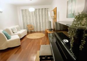 sala de estar con piano y sofá en Espaçoso T3 com terraço & churrasqueira en Campo
