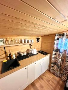 a kitchen with white cabinets and a stove at Domek drewniany in Podzamcze