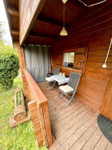 a wooden deck with two chairs and a table on it at Domek drewniany in Podzamcze