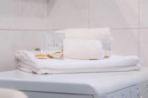una pila de toallas sobre una lavadora en Casa Spezia - Metro Vicina, Wi-Fi Rapido & Netflix en Turín
