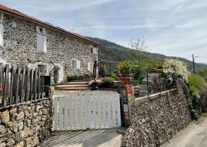 uma casa de pedra com um portão e uma parede de pedra em La Bruyère - chez Martine em Appy