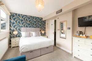 a bedroom with a white bed and a wall mural at Bowness Guest House in Bowness-on-Windermere