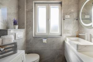a bathroom with a toilet and a sink and a mirror at Villa Big Garden in Primorski Dolac +46 photos