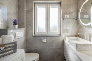 a bathroom with a toilet and a sink and a mirror at Villa Big Garden in Primorski Dolac
