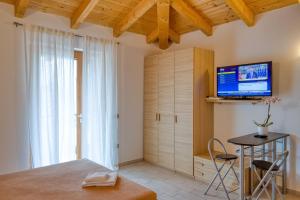 ein Schlafzimmer mit einem Bett und einem TV an der Wand in der Unterkunft Villa Camporosso in Colà di Lazise