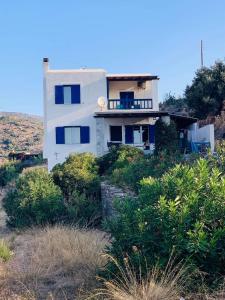 a house on the side of a hill with bushes at Batsi Bay View Maisonette in Andros