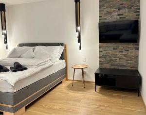 a bedroom with a bed and a table and a flat screen tv at Apartmán Panenská in Prague +11 photos
