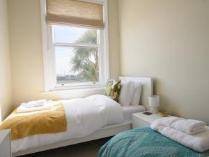 a bedroom with a white bed and a window at Sunrise View in Seaton