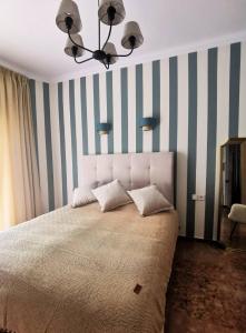 um quarto com uma cama grande com riscas azuis e brancas em Maison De Prestige em Chalkida