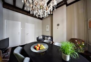 a dining room with a table with a plate of fruit on it at city Apartment "Op de Thermen" in Maastricht