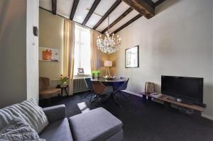 uma sala de estar com um sofá e uma mesa em city Apartment "Op de Thermen" em Maastricht