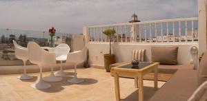 a balcony with a table and chairs on a balcony at Dar YAMAR in Essaouira