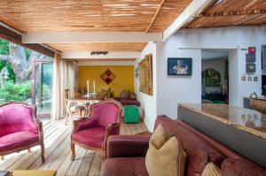 格雷頓的住宿－Art Box，客厅铺有木地板,配有粉红色的椅子