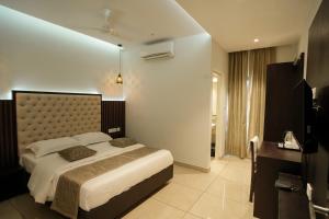1 dormitorio con 1 cama grande en una habitación en Sulu Residency en Ernakulam