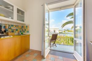 a kitchen with a sliding glass door leading to a balcony at Le Grand Bleu - Gioia Apartments in Procida