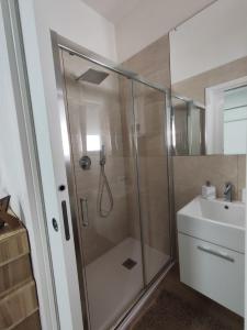 ein Bad mit einer Dusche und einem Waschbecken in der Unterkunft Iris Casa Vacanza in Noci