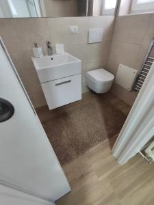 ein Badezimmer mit einem weißen Waschbecken und einem WC in der Unterkunft Iris Casa Vacanza in Noci