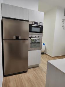 eine Küche mit einem Kühlschrank aus Edelstahl und einem Backofen in der Unterkunft Iris Casa Vacanza in Noci