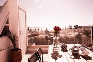 a table with a vase of flowers on a balcony at Dar YAMAR in Essaouira