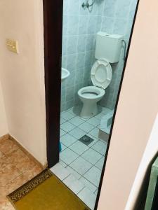 a bathroom with a toilet and a tile floor at Urban Apartments in Ulcinj