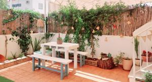 un patio avec deux bancs et une clôture avec des plantes dans l'établissement A Mar, à El Rompido