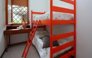 a red bunk bed with a desk and a ladder at Villa Capinera in Lignano Sabbiadoro