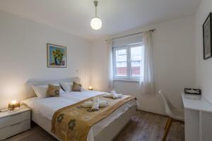 a white bedroom with a large bed with a window at App Sophia in Pula