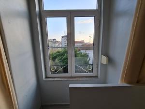okno w pokoju z widokiem na miasto w obiekcie Shangri-La Hostel Anjos w Lizbonie