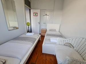 3 camas sentadas en una habitación con espejo en Shangri-La Hostel Anjos, en Lisboa
