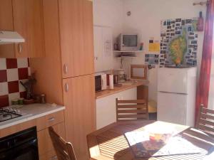eine kleine Küche mit einem Tisch und einem Kühlschrank in der Unterkunft Ducourneau Grimaldi in Moltifao + 16 Fotos