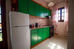 Una cocina con gabinetes verdes y un refrigerador blanco. en Georgia Apartment Acharavi Corfu, en Acharavi 19 fotos más