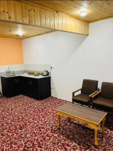 斯利那加的住宿－Ashai Villa Studio Apartment in Srinagar，一间设有桌子和两把椅子的房间和一间厨房