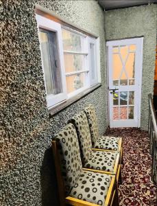 a living room with a couch and two windows at Ashai Villa Studio Apartment in Srinagar in Srinagar