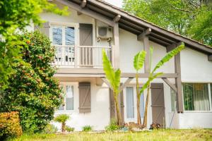 Casa blanca con balcón y árbol en Villa Ersanavera, en Saubrigues