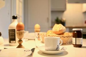 una mesa con huevos y una taza de café. en NORDSEE Bauernhof Familie Wulff FeWo "Südfall", en Reußenköge