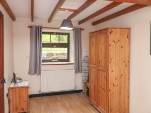 a room with a wooden cabinet and a window at Cow Byre Cottage in Whitby
