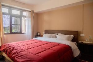a bedroom with a large red bed with a window at Sahaki Homestay in Shillong