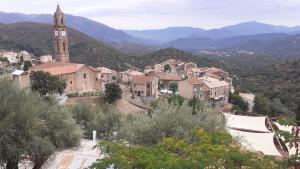 eine Stadt mit einem Glockenturm und einer Kirche in der Unterkunft Ducourneau Grimaldi in Moltifao