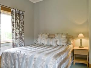 a bedroom with a bed and a window at Sgurr Mor Lodge - Smmd in Balmacara