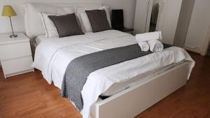 a large white bed with two towels on it at Gare-30A-3 in Lausanne