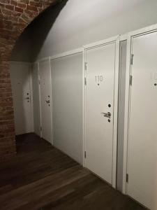 a room with white doors and a brick wall at Old Town Stay Hostel in Stockholm