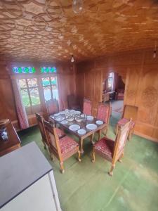comedor con mesa y algunas sillas en Houseboat Young Manhattan en Srinagar