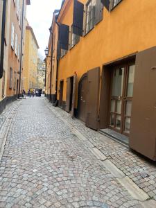 eine leere Kopfsteinpflasterstraße in einer Stadt mit Gebäuden in der Unterkunft Old Town Stay Hostel in Stockholm