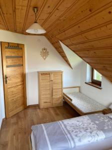 a bedroom with a bed and a wooden ceiling at Domek Letniskowy in Zubrzyca Dolna