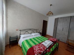 a bedroom with a bed with a green and white blanket at Agriturismo Il Falco in Todi