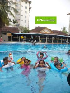 a group of children swimming in a swimming pool at Ocean view resort homestay near beach free wifi,cucckoo 3ROOM in Port Dickson